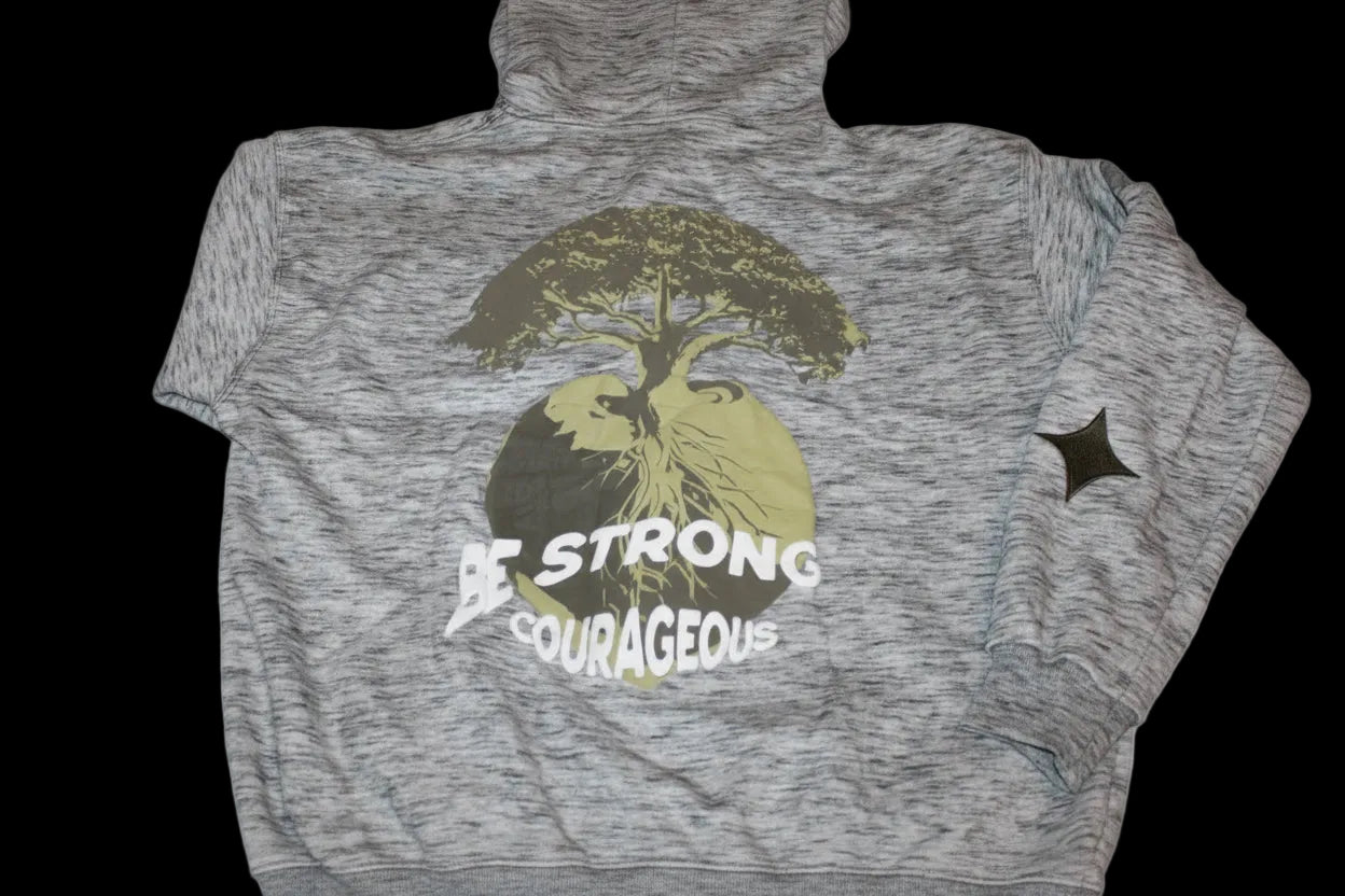 Gray jacket with a tree graphic and puff print 'Be Strong Be Courageous' text .